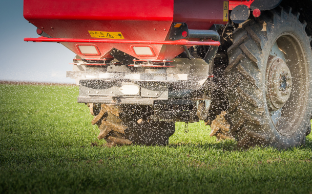 fertilizer Red, Electric Broadcast Fertilizer Spreader, Spreading White Seeds on Green Grass